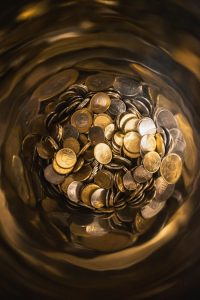 A close-up of assorted Euro coins with a warm, blurred background.