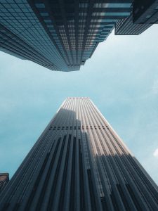 Low angle view of towering skyscrapers under a clear blue sky, showcasing urban architecture.